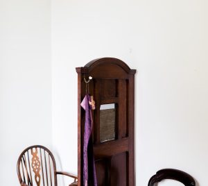 brown wooden cabinet beside brown wooden windsor armchair