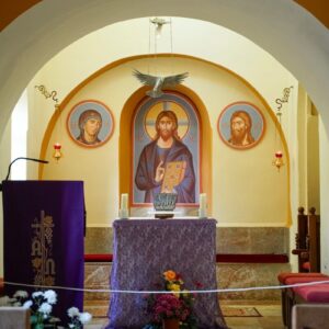 Altar with religious icons and flowers in church.