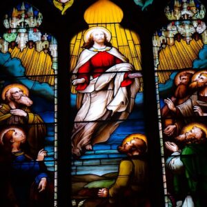 A stained glass window with a painting of jesus on it