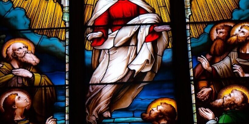 A stained glass window with a painting of jesus on it